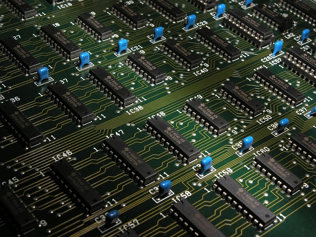Computer CPU processor chip removed from motherboard, showing metallic surface and pins