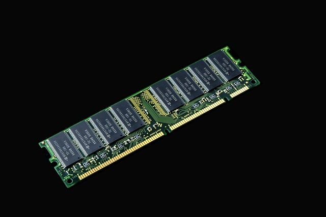 RAM memory module with green circuit board and black chips for computer use.